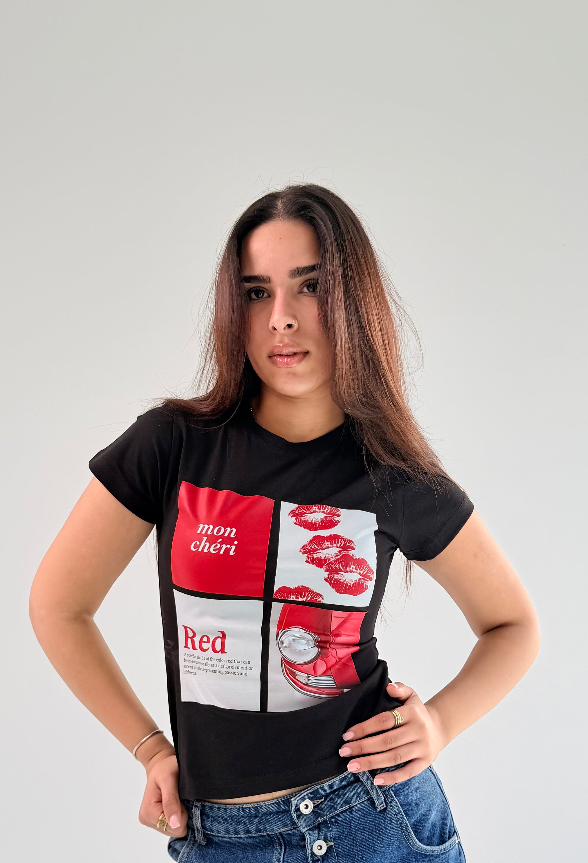 Woman wearing a black t-shirt with a colorful graphic design on a plain background