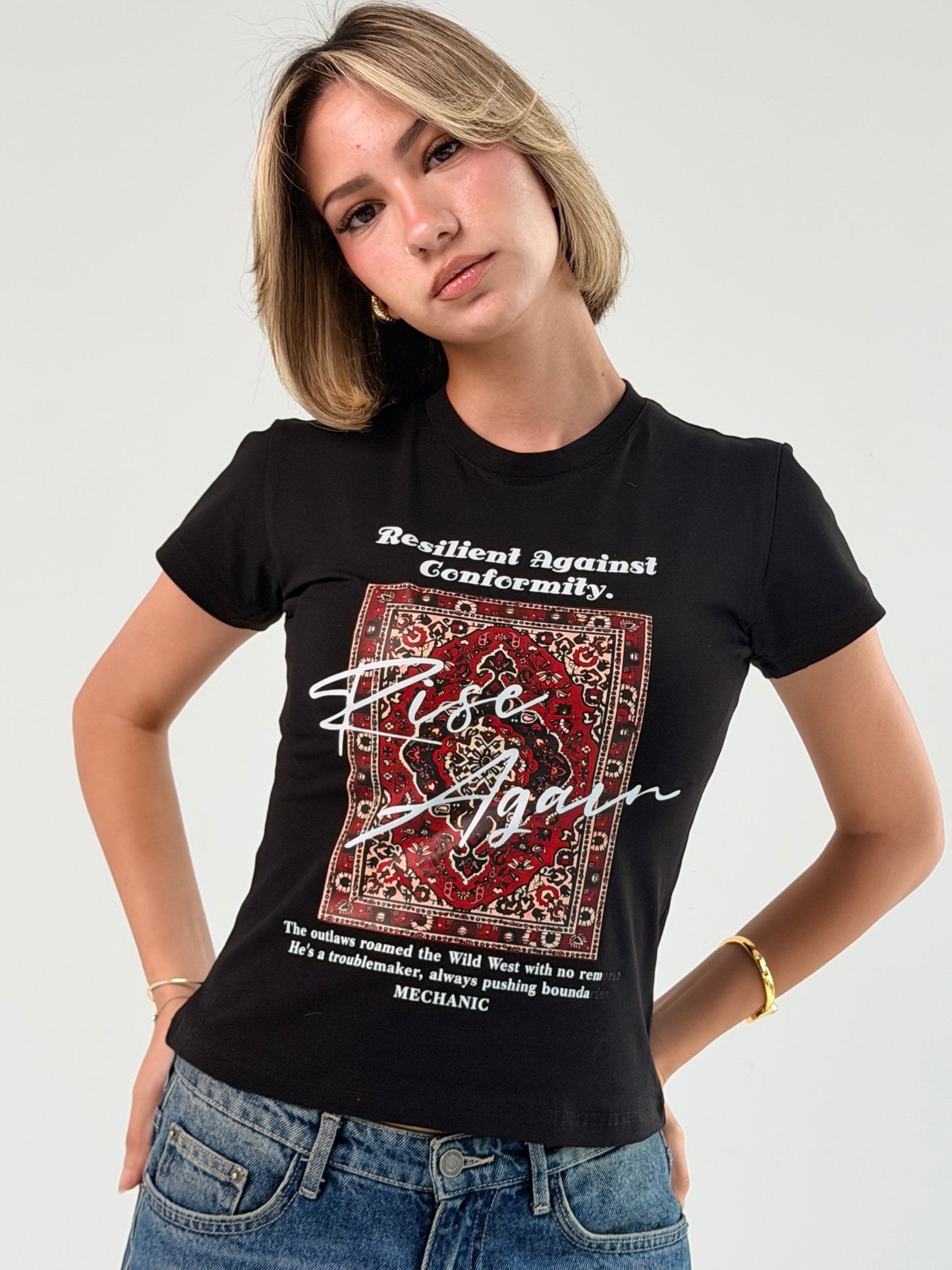 Person wearing a black t-shirt with graphic design and text on a plain background